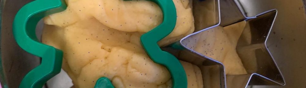Green man cookie cutter and star cookie cutter on top of playdough